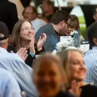 An audience member applauds during a benefit dinner and auction.