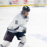 A hockey player zooms across the ice during a game.
