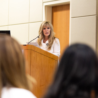 Students listen to speakers at a graduation and then receive their pins, signifying graduation.