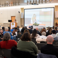 Students listen to speakers at a graduation and then receive their pins, signifying graduation.