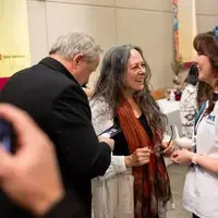 Students listen to speakers at a graduation and then receive their pins, signifying graduation.