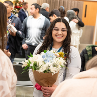 Students listen to speakers at a graduation and then receive their pins, signifying graduation.