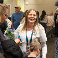 Students listen to speakers at a graduation and then receive their pins, signifying graduation.
