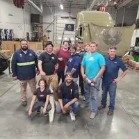 Group of people posing in an automotive space