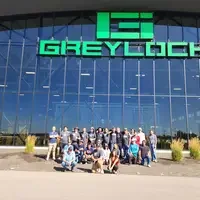Group of people posing for a photo in front of a business