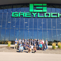 Group of people posing for a photo in front of a business