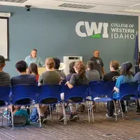 Group of people in a classroom listening to speakers