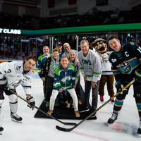 Group of people on the ice doing the puck drop