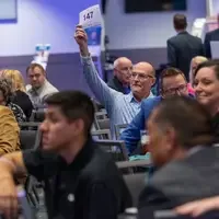 Donor holds up paddle for auction