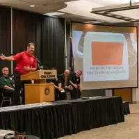 Speaker presenting award on a screen.