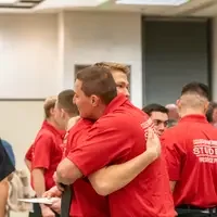 Two graduates hugging.