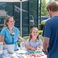 Staff chatting with student at booth