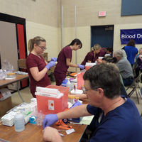 Phlebotomy students working at table