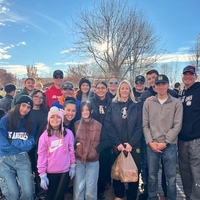 Group of people standing outside in front of tree
