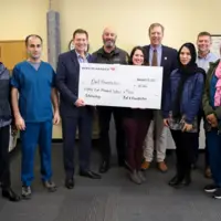 Students and leaders holding a check