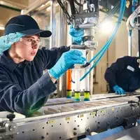 Student working on assembly line machine