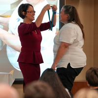 Person pinning graduate