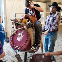 Kid learning to ride fake bull