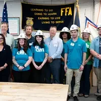 A group of students and executives pose for a photo.