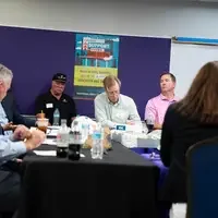 Executives sit at a table for a working meeting.