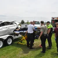 Advanced EMT students putting person on stretcher.