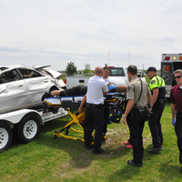 Advanced EMT students putting person on stretcher.