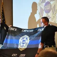 A class flag is presented by graduates at the Law Enforcement program ceremony.