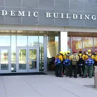 Firefighters meeting outside the academic building