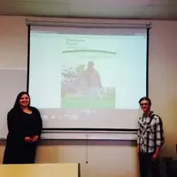 Marketing students in front of classroom giving presentation.