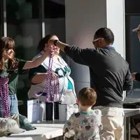 A student receives a multi-colored stole to wear at commencement.