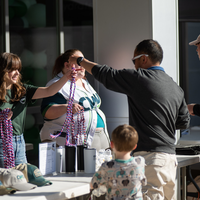 A student receives a multi-colored stole to wear at commencement.
