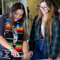 Two students decorate their graduation caps during Grad Fest 2024 at CWI.