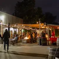 People under canopy with lights and barrels 