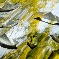 Paper boats under a colorful projection