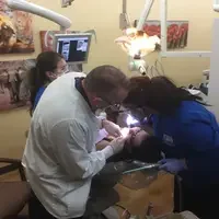 Dental Students working on a patient with dentist and aid
