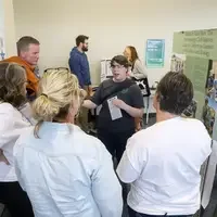 Student presenting poster to judges