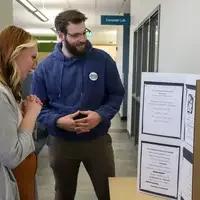 Student showcasing poster presentation