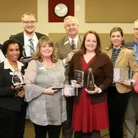 Mary (M.C.) Niland stands with fellow board members, staff, and students. She served as a founding trustee from 2007 to 2020.