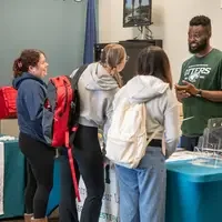 Groups of students chatting with staff at fair