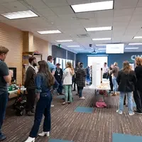 Room full of people gathering around presentations