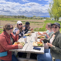 Students gathering around a table eating lunch