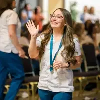 Student waving to family and friends