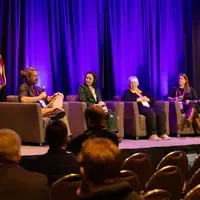 Group of people sit in chairs on stage