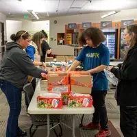 Students working together to fill bags with food and hygiene products