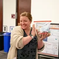Student poses with filled bag of food and hygiene products