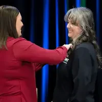 Smiling student being pinned by instructor 