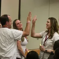 Professional Nursing students high five after pinning ceremony