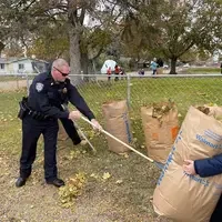 Sheriffs Deputy raking up leaves