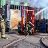 Students using hose to put out fire