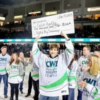 Caleb Updike holding up check